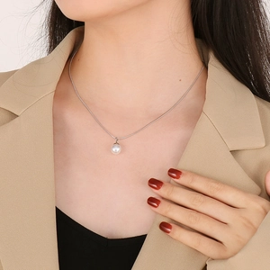 Dettaglio della collana in titanio argento con perla bianca indossata dalla modella