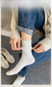 Detail of white rib-knit crew socks showing high elasticity and seamless toe craftsmanship