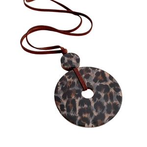 Minimalist leopard print acrylic round pendant necklace with brown cord on white background