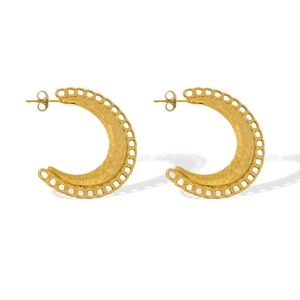 Détail de boucles d'oreilles créoles en C dorées avec texture gravée complexe