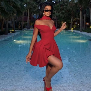 Detail of red off-shoulder mini dress with neck strap and pleated skirt at poolside