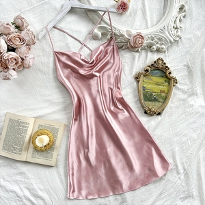 Pink satin slip dress with cowl neck and crisscross straps on a romantic French background