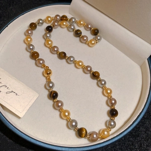 Détail macro du bracelet français vintage en oeil de tigre et perles dans sa boîte cadeau