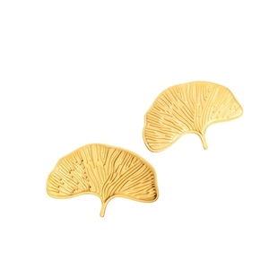 Matte gold ginkgo leaf earrings made of vintage stainless steel on white background