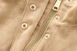 Macro shot of camel suede texture with golden metallic zipper and decorative studs on jacket