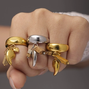 Set di anelli in acciaio oro e argento con pendenti in giada su una mano