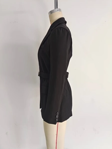 Détail de profil d'un blazer noir mi-long avec ceinture assortie et poignets à boutons
