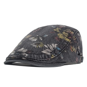 Detail of washed denim beret featuring floral daisy print and metal adjustment buckle