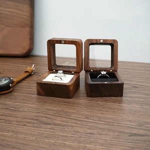 Walnut wood jewelry box with clear window showing rings on black and white linings