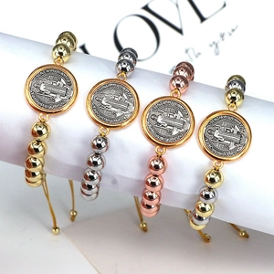 Detailed macro view of four religious Saint Benedict beaded bracelets in metallic finishes
