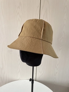 Detail of khaki nylon sun hat with contrast white stitching and quilted brim design