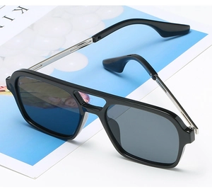 Close-up of black aviator sunglasses with double bridge design and silver metal temples