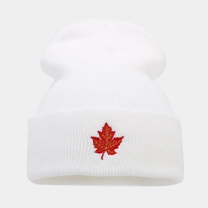 Detail of red maple leaf embroidery on a white ribbed knit beanie for winter