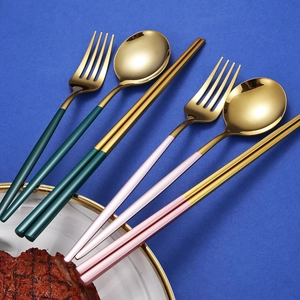 Green and pink 304 stainless steel cutlery set with gold finish on a blue background