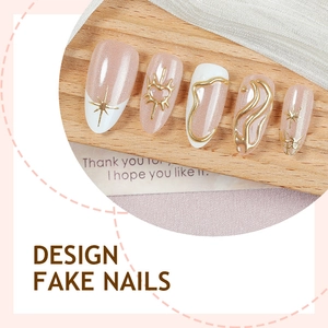 Faux ongles amande French avec motifs 3D dorés et accents de perles œil de chat