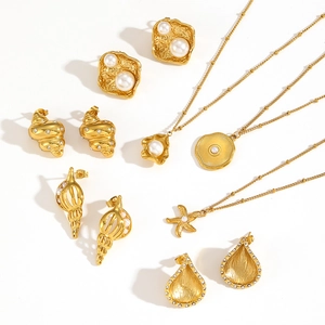 Flat lay of gold starfish necklaces and pearl shell earrings on white backdrop