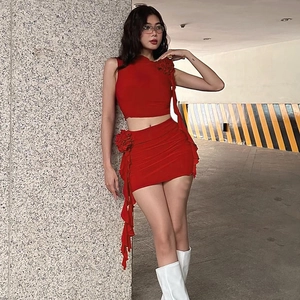 Detailed view of red two-piece set featuring 3D floral accents and ruffled mini skirt