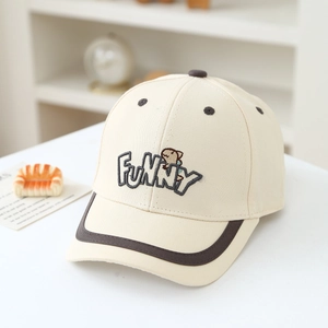 Close-up of funny dinosaur embroidery and premium stitching on a beige cotton kids baseball cap
