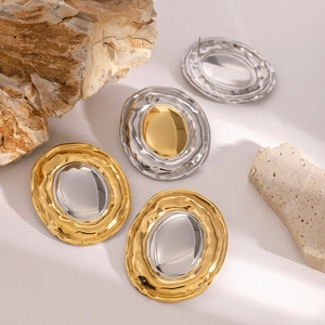 Modern two-tone gold and silver oval earrings with textured metal finish and bold design