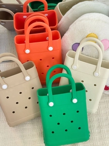Macro top view of colorful EVA beach bags in vibrant orange, green and cream white