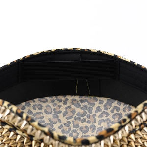 Macro shot of leopard print hat interior showing golden rivets and black sweatband