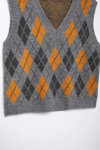 Detailed knit texture of vintage argyle vest with grey and mustard diamond patterns