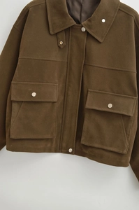 Detail der dunkelbraunen Cargo-Jacke mit Wildleder-Textur, Pattentaschen und Druckknöpfen