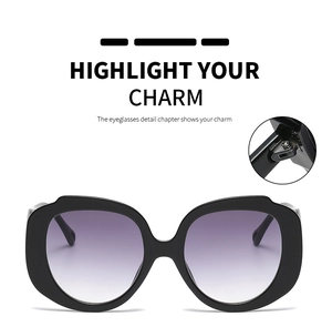 Detail of round oversized sunglasses featuring black frames and reinforced metal hinges
