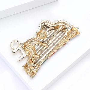 Detailed back view of golden cat harp brooch with textured finish and secure pin clasp