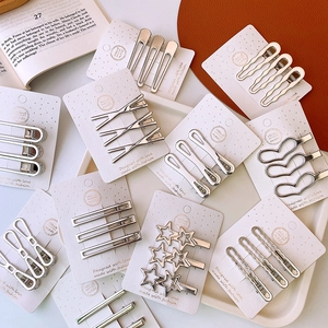 Close-up of silver hollow star and heart metal hair clips on white display card