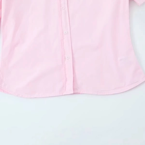 Minimalist pink poplin button-down shirt for women with clean and smooth fabric texture