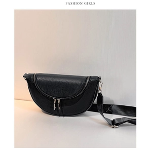 Detail of black lychee grain leather crossbody bag with silver zippers and nylon strap