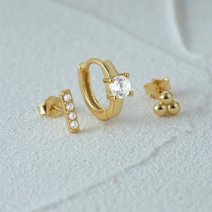 Detailed view of 925 silver gold-plated earring set with cubic zirconia on white rock