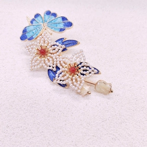Detailansicht der blauen Schmetterlings-Haarklammer mit weißen Perlen und Gold