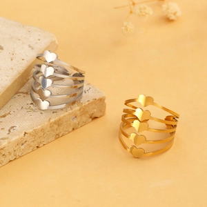Detail showing stacked multi-layer heart rings in gold and silver stainless steel finish