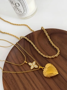 Détail de colliers en titane or 18K avec breloques cœur vintage et fleur en cristal