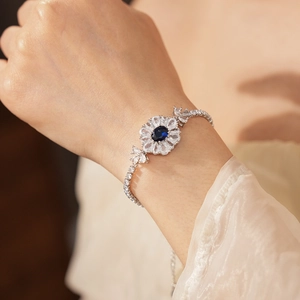 Detaillierte Nahaufnahme eines silbernen Blumenarmbands mit funkelndem blauem Zirkonia