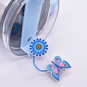Detail of blue flower and butterfly silicone straw covers with a clear tumbler lid