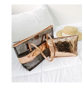 Detail of rose gold transparent PVC tote bag with matching inner pouch on white bedding