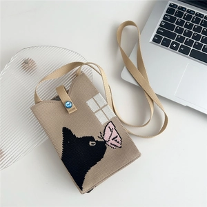 Close-up of khaki knit mini bag featuring black cat jacquard and blue jewel button closure