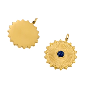 Detail of sunburst gold pendant featuring deep blue gemstone inlay and polished back