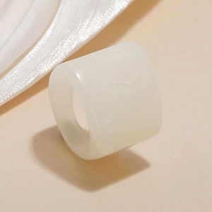Macro shot of wide pearlescent resin ring with smooth ivory finish and luxury texture