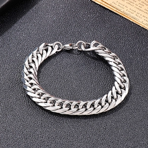 Close-up of polished silver Cuban link bracelet with a secure lobster clasp on dark texture