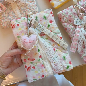 Détail de la trousse de maquillage matelassée fleurie avec dentelle et pendentif