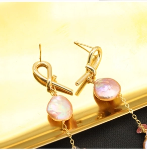 Macro shot of high-quality baroque pink pearls with 18k gold plated metal earring details