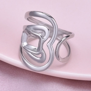 Détail d'une bague géométrique en acier inoxydable argenté sur soie rose