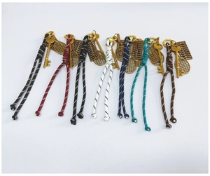 Overview of seven colorful woven keychains with vintage gold tennis racket and key charms