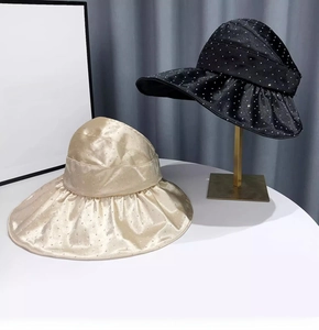 Detailed view of rhinestone sun visors in black and beige with a wide brim for summer
