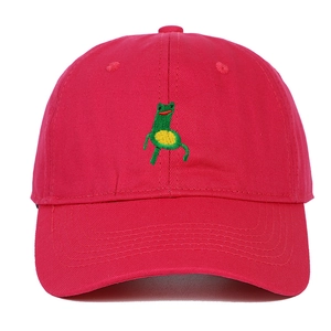 Detailed close-up of green cartoon frog embroidery on red cotton baseball cap