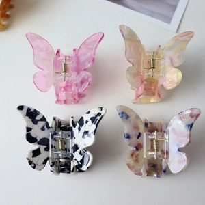 Detail view of four colorful butterfly claw clips in acetate resin with metal springs